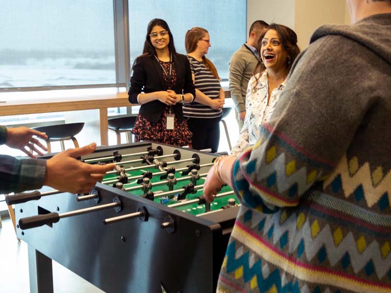 Zions Bancorporation employees playing foosball at the Technology Center